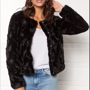Svart pälsjacka - Snygg svart pälsjacka med knappar framtill. Som ny.