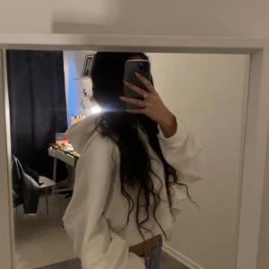 Vit oversize croppad hoodie från Monki - Säljer en vit croppad hoodie från Monki i ekologisk bomull. Den har en avslappnad passform med långa ärmar och en klassisk huva. Perfekt för en casual look. 🌟