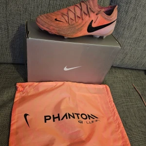 NIKE Phantom GX 2 Elite fg fotbollsskor EUR 42 - Nike Phantom GX II Elite FG fotbollsskor i färgen Sunset Pulse/Black.  Storlek 42.  Bra skick, varit på planen mindre än en halv säsong, syns på färgen mest. 550kr