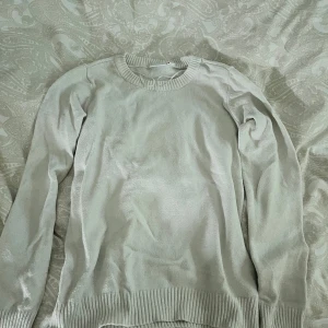 Vit tröja från VILA - Säljer en stilren beige tröja från VILA. Tröjan har långa ärmar och ribbade kanter vid hals, ärmslut och nederkant. Perfekt för en avslappnad och bekväm look.