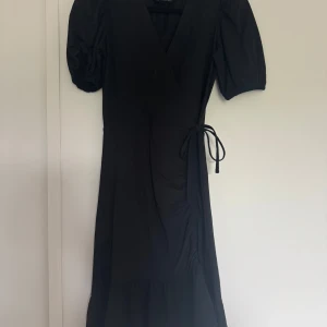 Svart omlottklänning med puffärm - Jätte fin klänning från Gina Tricot i svart!!🥰