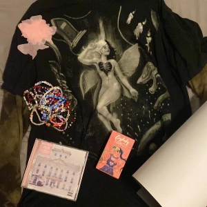 Melanie Martinez merch💕 - Säljer detta då jag inte lyssnar på henne längre🫶🏼, vill bli av med sakerna fort. T-Shirt 300kr, long sleeve 400kr, tarot kort 30kr, armband 10-15kr st, confetti 30kr 2st, cd 120kr, portals posters liten 70kr stor 90kr, trilogy tour poster 950kr💕1800kr för ALLT🫶🏼 pris kan diskuteras💕