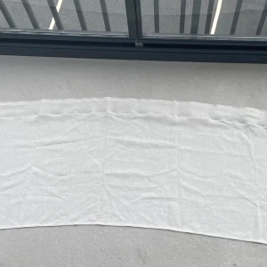 Vit linne gardinkappa i enkel design - En stilren och tunn vit gardinkappa i linne. Perfekt för att ge en fräsch touch till rummet. Rektangulär form och lätt material som känns svalt. Passar dig som gillar minimalistisk stil. Bredd: 242cm Längd: 52,5cm