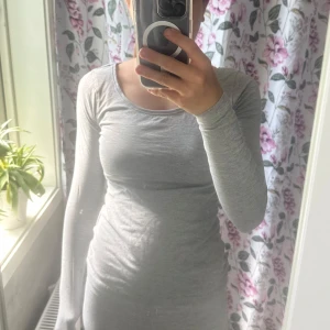 Grå långärmad tight tröja - Säljer en enkel och stilren grå långärmad tröja med tight passform. Perfekt basplagg med rund halsringning, passar till allt och är superbekväm. Materialet känns mjukt och följsamt mot kroppen.