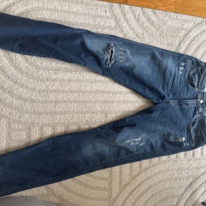 Replay mörkblå slim jeans med slitningar - Säljer ett par mörkblå Replay anbass jeans med snygga slitningar. W34 L34