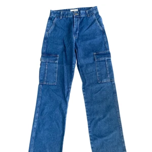 Blå cargojeans  - Säljer ett par blå cargojeans från Levi's med raka ben och stora fickor på sidorna. Klassisk denim med normal passform och midja. 