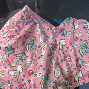 Rosa My Little Pony kortkjol från Hasbro - Supergullig rosa kortkjol med My Little Pony-tryck, regnbågar, stjärnor och fjärilar. Kjolen är i 100% bomull och har färgglada detaljer som verkligen poppar. Perfekt för dig som älskar färg och lekfulla mönster! Storlek 122-128