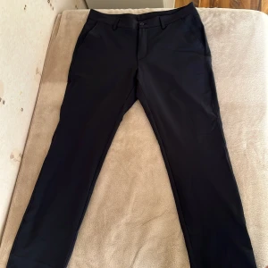 Golfbyxor Under Armour 35/34 - Svarta UA Matchplay Tapered golfbyxor i storlek 35/34. Helt oanvända, vart lite för stora för mig. Nypris 879 kr. Säljer för 500 kr.