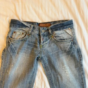 Blå jeans från Replay - Snygga blå jeans från Replay med bootcut-stil och slitna detaljer. De har en unik broderad detalj på bakfickan och klassisk femficksdesign. Perfekta till vardags!💖💖