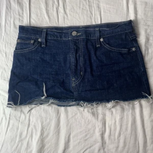 Levi's jeanskjol med fransig kant - Mörkblå jeanskjol från Levi's med klassiska fickor fram och bak, fransig rå kant nertill och synliga sömmar. Pris kan diskuteras! 💗
