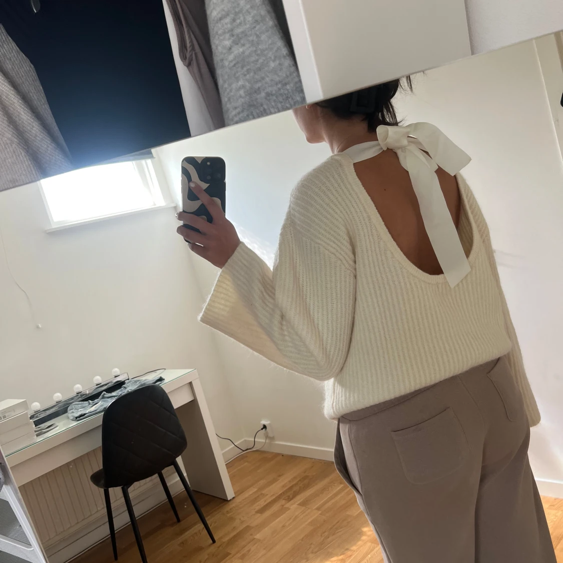 Vit stickad tröja med rosett i ryggen från ginatricot