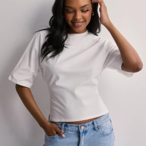 Nelly tishirt  - Snygg T-shirt från Nelly med knytning i ryggen, knappt använd 