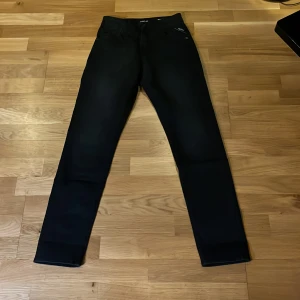 Svarta Replay Slim Boyfit jeans Marty modell aldrig använda  - Snygga svarta jeans från Replay i modellen Slim Boyfit. De har en smal passform med raka ben och klassisk femficksdesign. Jeansen är tillverkade i ett stretchigt material som ger en bekväm känsla och sitter riktigt bra på kroppen.