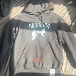 Svart Hoodrich hoodie  - Svart Hoodrich hoodie i storlek S.har et litet grönt märke på texten på framsidan vilket jag är osäker om man kan ta bort