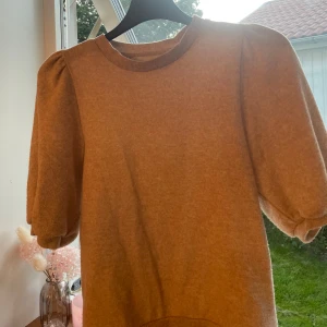 Beige stickad klänning från lager 157 i XS -  beige stickad tröja från lager 157 i storlek XS. Modellen har puffiga korta ärmar och rund halsringning. Den är lite nopprig eftersom den är använd men inga fläckar.