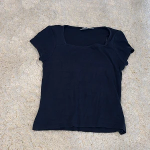 Mörkblå topp från Gina Tricot - En basic mörkblå topp från Gina Tricot med korta ärmar och fyrkantig ringning. Använd men inget man märker av