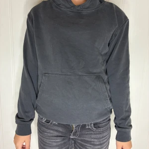 Mörkgrå hoodie från H&M BASIC - En enkel och stilren mörkgrå hoodie från H&M BASIC. Tröjan har huva, magficka och ribbade muddar vid ärmslut och nederkant. Färgen är lite urtvättad. Säljer på grund av att den är för lite för mig. Pris kan diskuteras❤️