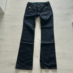 Mörkblå bootcut jeans - Snygga mörkblå jeans med bootcut passform och klassisk femficksdesign. Jeansen har låg midja och är tillverkade i ett robust denimtyg som ger en tidlös look. 
