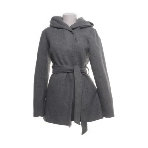 Grå kappa med huva från Amisu - Stilren grå kappa från Amisu med huva och knytskärp i midjan. Jackan har en rak passform, långa ärmar och är tillverkad i mjuk polyester. Perfekt för dig som gillar en enkel men snygg look under kyliga dagar.