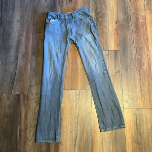 Grå raka jeans från Diesel - Snygga grå jeans från Diesel med klassisk femficksdesign och raka ben. Jeansen har diskreta sömmar, normal passform och är tillverkade i mjukt denimtyg. Perfekta för dig som gillar en clean och tidlös look. Billigt pris pågrund av ett lite litet hål