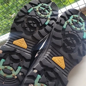 Svarta mockaboots med dragkedja - Svarta boots i mocka med grov sula och dragkedja på sidan. Insidan är fodrad med mjukt material för extra värme. Sulan har gröna detaljer och metallpiggar för bra grepp. Perfekta för kalla dagar när du vill ha både stil och funktion.