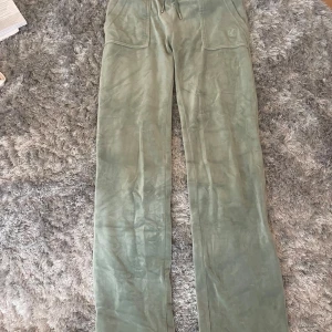 Gröna mjukisbyxor Juicy Couture XS - Snygga gröna mjukisbyxor från Juicy Couture i mjukt material. Byxorna har raka ben, snörning i midjan och stora fickor med knappar bak. Knappt använda💗Säljer då de är för små💗Pris kan diskuteras vid snabb affär❤️