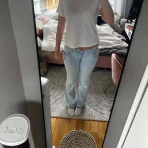 Ljusblå bootcut jeans med låg midja - Säljer ett par ljusblå jeans med bootcut och låg midja. Jag har sprättat upp längst ner på benen pga de var för korta, jag är 176cm. Jeansen är knappt använda💗
