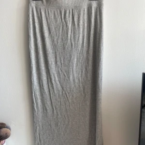 Grå ribbad långkjol från 157 - Säljer en grå ribbad långkjol från 157 i storlek XS. Kjolen har en slits på sidan. Använd en gång, säljer då den är för kort för mig