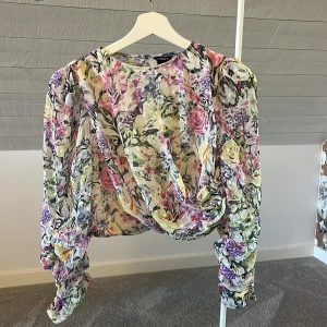 Blommig blus med puffärm - Superfin blommig blus med färgglada blommor i lila, rosa, gul och grön. Blusen har puffiga långärmar med rynkade detaljer och croppad passform🩷💚💛🧡💙🩵