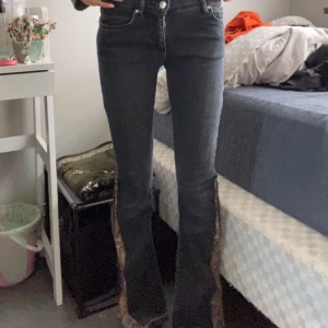 Svarta bootcut jeans med ormmönster - Svarta lågmidjade jeans men omönstrat i ändan. Jag har köpt jeansen av en annan från vinted så de har sytt ormönstern på byxorna. Har inte använt de någon gång sen ja fick de , eftersom de inte passade mig 💕