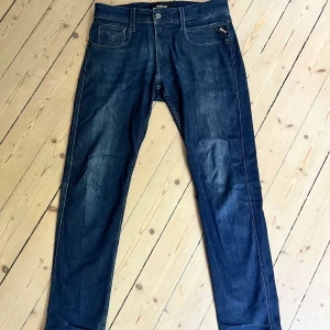 Replay Anbass jeans mörkblå, stl 31 - Snygga mörkblå Replay Anbass jeans i klassisk femficksmodell. Jeansen har raka ben, normal passform och är tillverkade i mjukt denimtyg. Perfekta för dig som gillar stilrena och tidlösa jeans med diskreta detaljer.