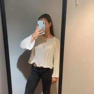 Vit stickad  tröja med mönster - Säljer en vit stickad tröja med lång ärm och snyggt hålmönster. Tröjan har en vågig kant nedtill med en loose passform. Perfekt för dig som gillar en chill och trendig stil. Passar till både jeans och kjol. Använd fåtal gånger