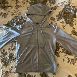 Ljusblå hoodie från Gina Tricot - Säljer en ljusblå hoodie från Gina Tricot i storlek XS. Tröjan har dragkedja framtill, snörning vid huvan och två fickor. Mjuk och skön polyesterkvalitet,Långärmad och med klassisk passform. Säljer då den inte kommer till användning längre. Mycket bra skick!