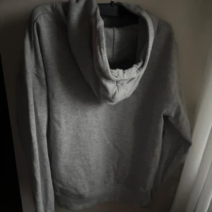 Grå hoodie från Wai Wai - Säljer en enkel grå hoodie från Wai Wai i mjuk bomull. Tröjan har huva, lång ärm och en stor ficka framtill. Använd några gånger men inga defekter. Läs gärna bio. OBS skriv innan köp!❤️