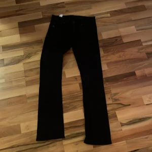 Svarta byxor från Tiger of Sweden - Snygga svarta byxor från Tiger of Sweden slim fit. Byxorna har diskreta detaljer och är tillverkade i ett mjukt material som känns bekvämt hela dagen. Perfekta för dig som gillar stilrena och tidlösa plagg.