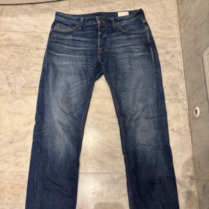 Blå jeansbyxor från Jack & Jones - Säljer dessa riktigt snygga taperd Jack & Jones jeans i snygg mörkblå tvätt. Storleken är 30/30 och dessa är i mycket bra skick. Nypris 700kr. 