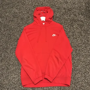 Röd Nike hoodie med logga - Säljer en röd hoodie från Nike i storlek M. Mjuk och skön, perfekt för chill eller träning. Har använts. Säljer denna pga för stor för mig nu. Önskas fler bilder så är det bara att hojta till.