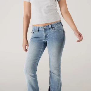 Ljusblå bootcut jeans från True Religion  - Snygga ljusblå jeans från True Religion med klassisk bootcut-passform och låg midja. Jeansen har fem fickor, bälteshällor och dragkedja med knapp. Perfekt för dig som gillar en avslappnad och trendig stil. Har knappt andvänt dom jätte bra skick. ( lånad bild från nätet) 