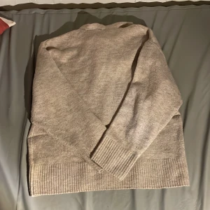 Beige stickad hoodie från Lindex - Mysig beige stickad hoodie från Lindex med ribbade muddar vid ärmslut och nederkant. Tröjan har en stor huva och är långärmad, perfekt för chill dagar. Materialet är mjukt och känns skönt mot huden. Passar dig som gillar enkel och clean stil.