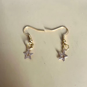 Örhängen med stjärna i guld - Säljer ett par trendiga silvriga örhängen. Ser lite silvriga ut men är guldiga. Örhängena är lätta och enkla att bära hela dagen. Gjord av mig💞30+22kr frakt =52kr. Tar bara Swish . TikTok: @jewelrybysara13