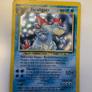 Pokemonkort- Feraligatr Neo Genesis holo - Samlarkort från Pokémon med Feraligatr, en kraftfull vatten-Pokémon. Perfekt för dig som gillar att samla eller spela Pokémonkort! Kortet har cool design och detaljerade stats, vilket gör det till ett måste för fans och unga samlare.