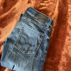 Slim fit jeans från Jack & Jones - Säljer ett par blå slim fit jeans från Jack & Jones, modell Glenn. Jeansen har super stretch, klassisk femficksdesign och normal midja. Perfekta för dig som gillar en smalare passform och bekvämt material.