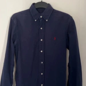 Mörkblå skjorta från Ralph Lauren - Riktigt snygg marinblå skjorta från Ralph Lauren! Mycket eftertraktad modell och speciellt färg. Slimfit skjorta i storlek S | Skick 10/10 näst intill ny. Skriv vid funderingar!