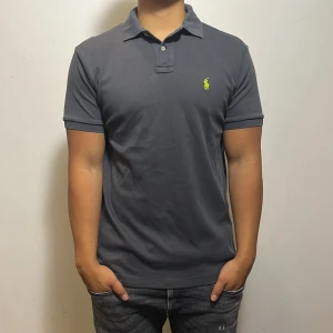 Mörkgrå pikétröja från Ralph Lauren - Säljer denna snygga Ralph lauren piken för endast 349kr. Skicket är perfekt utan några defekter (9/10) och är i storlek M. Om ni har några frågor så är det bara att höra av sig!!