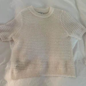Vit stickad kortärmad mohair tröja - Säljer en vit stickad tröja med korta ärmar och rund hals, lite genomskinlig i mohair. Toppen skick!! 