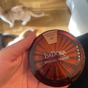 IsaDora Bronzing Powder Terracotta - IsaDora Bronzing Powder i nyansen 43 Terracotta Bronze. Kommer i en rund, brun plastförpackning med spegel i locket. Ger en varm, solkysst look med sin matta bronzefärg. Perfekt för att framhäva ansiktskonturer och ge glow.