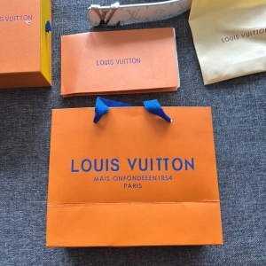 Vit Louis Vuitton bälte med silverfärgat LV-spänne - Säljer ett exklusivt vitt bälte från Louis Vuitton med ett stort, silverfärgat LV-spänne. Bältet har präglad logga på lädret och levereras med originalpåse och förpackning. Perfekt accessoar för att lyfta din outfit.