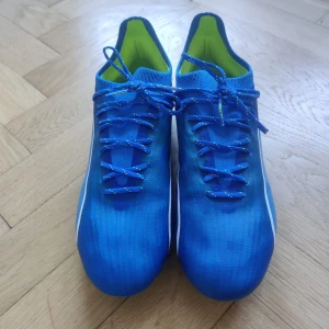 New Balance Fotbollsskor skruvdubb - Ett par fotbollsskor med skruvdobb, aldrig använda. Skorna är helt nya, endast provade inomhus. Väldigt skön modell från New Balance som tyvärr säljes för att de är för små. Hör av dig vid frågor eller prisförslag!