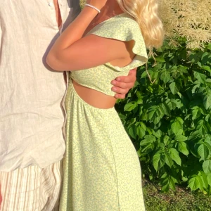 Gul blommig klänning - Säljer en söt gul klänning som har använda för en midsommar. små. Klänningen har korta volangärmar, v-ringning och öppning ovan midjan. Superbekväm för varmare dagar!