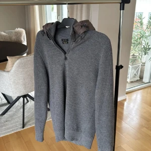 Utsåld cardigan  från Massimo Dutti - Säljer en grå ribbstickad hoodie från Massimo Dutti med dragkedja och huva med snörning. Tröjan har långärmad passform och är tillverkad i mjuk ullblandning med elastan för extra komfort. Perfekt nu inför hösten Storlek L 